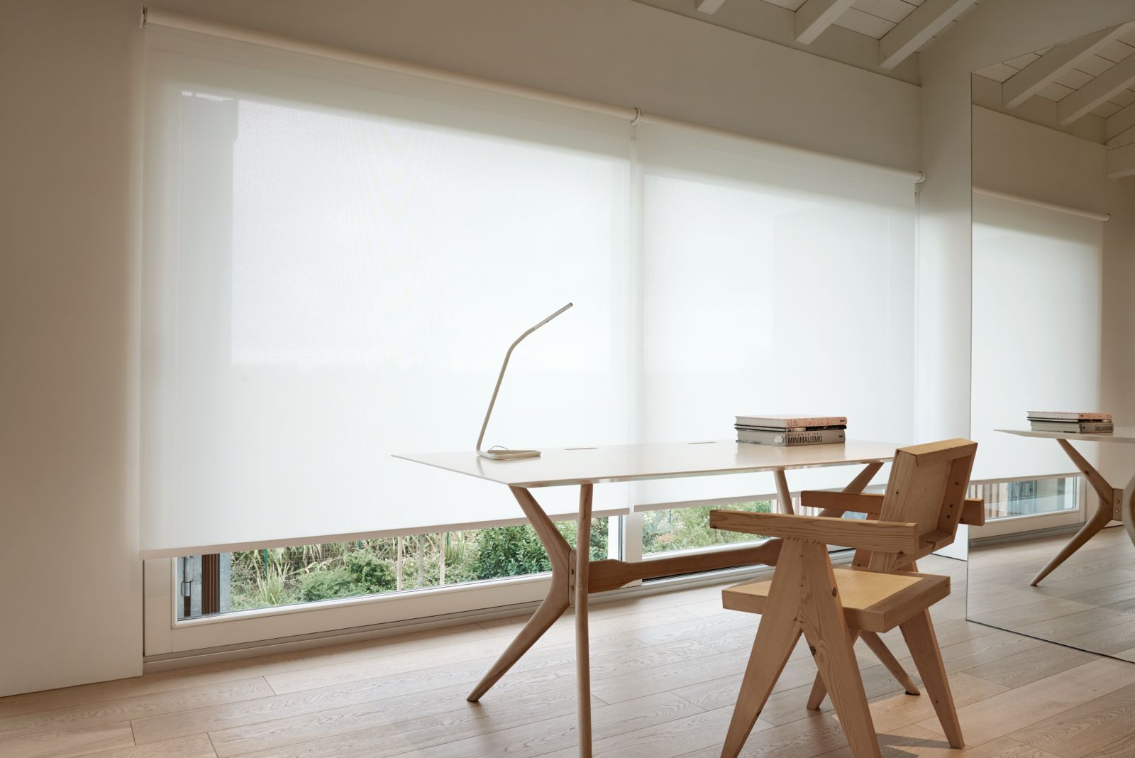 Wit screendoek voor grote raampartijen in een lichte werkruimte met houten bureau en stoel